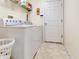 Clean laundry room with a white washer and dryer, complemented by storage shelves at 1216 Cheshire St, Groveland, FL 34736
