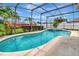 Inviting screened-in pool and spa area, surrounded by lush landscaping at 1216 Cheshire St, Groveland, FL 34736