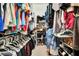 Functional walk-in closet features an abundance of clothing and a diverse array of shoes neatly arranged at 1216 Cheshire St, Groveland, FL 34736