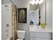Bright bathroom featuring a tub with shower, single sink, and elegant decor at 13108 Serene Glade Rd, Winter Garden, FL 34787