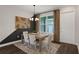 Modern dining area with neutral tones, stylish decor, patterned rug, and a large window for natural light at 13108 Serene Glade Rd, Winter Garden, FL 34787
