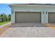 Exterior view of a two car garage with a brick paver driveway at 13108 Serene Glade Rd, Winter Garden, FL 34787