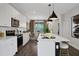 Modern kitchen with white cabinets, stainless steel appliances, island with bar seating, and adjacent dining area at 13108 Serene Glade Rd, Winter Garden, FL 34787