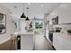 Open-concept kitchen with white cabinets, stainless steel appliances, kitchen island with barstool seating and pendant lights at 13108 Serene Glade Rd, Winter Garden, FL 34787