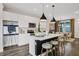 Modern kitchen features white cabinetry, a kitchen island with pendant lights, and an adjacent dining area at 13108 Serene Glade Rd, Winter Garden, FL 34787