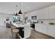 Open-concept kitchen featuring white cabinets, stainless steel appliances, a kitchen island, and bar stool seating at 13108 Serene Glade Rd, Winter Garden, FL 34787