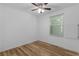 Cozy bedroom features a ceiling fan, window, and wood-look flooring at 1421 E Schwartz Blvd, The Villages, FL 32159