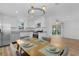 Kitchen and dining area with stainless appliances, white cabinets, and dining table setting at 1421 E Schwartz Blvd, The Villages, FL 32159