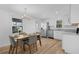 Bright kitchen features stainless steel appliances, wood floors, white cabinets, and a stylish dining area at 1421 E Schwartz Blvd, The Villages, FL 32159
