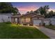 Charming single Gathering home with manicured lawn, brick accents, and warm exterior lighting at dusk at 149 Shiloh Ave, Lady Lake, FL 32159