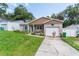 Charming home featuring a manicured lawn, brick accents, and an inviting covered porch with seating at 149 Shiloh Ave, Lady Lake, FL 32159
