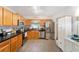 Well-lit kitchen with stainless steel fridge, wood cabinetry, and a modern black countertop at 149 Shiloh Ave, Lady Lake, FL 32159