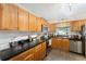 Clean kitchen with black countertops, ample wood cabinets and modern appliances, offering functionality at 149 Shiloh Ave, Lady Lake, FL 32159
