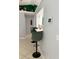 View of the kitchen bar with green chairs, white countertop, and a security system on the wall at 15349 Lafite Ln, Clermont, FL 34714