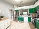 View of kitchen with stainless steel appliances, green cabinets, and a tile floor at 15349 Lafite Ln, Clermont, FL 34714