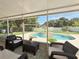 Screened patio with wicker furniture and views of the backyard pool at 15349 Lafite Ln, Clermont, FL 34714