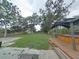Expansive backyard with lush green grass and mature trees, featuring a hot tub with gazebo on a wooden deck at 1610 Williams Ave, Eustis, FL 32726