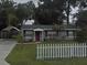 Charming single-story home featuring a well-maintained lawn, picket fence, and covered carport at 1610 Williams Ave, Eustis, FL 32726