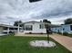 Charming single-story home featuring a well-maintained lawn, white exterior, and convenient covered parking at 163 Sweet Cir, Winter Haven, FL 33884
