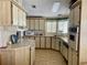 Cozy kitchen with tile flooring, a window, and upper and lower wood cabinets at 163 Sweet Cir, Winter Haven, FL 33884