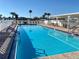 Inviting outdoor pool area with clear blue water, surrounded by lounge chairs and a covered patio at 163 Sweet Cir, Winter Haven, FL 33884