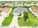 Aerial view showcasing a meticulously landscaped property, complete with a pristine lawn and attached two car garage at 1654 Blossom Ter, The Villages, FL 32162