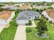 Aerial view showcasing a meticulously landscaped property, complete with a pristine lawn and attached two car garage at 1654 Blossom Ter, The Villages, FL 32162