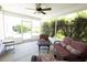 Enjoy a relaxing screened-in patio with a ceiling fan and outdoor seating area with a view of the landscaped backyard at 1654 Blossom Ter, The Villages, FL 32162