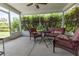 Relaxing enclosed patio with cozy seating and a view of the manicured lawn for serene outdoor enjoyment at 1654 Blossom Ter, The Villages, FL 32162