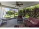 Enclosed patio with ceiling fan, outdoor furniture set, and a view of the well-maintained backyard, perfect for relaxation at 1654 Blossom Ter, The Villages, FL 32162