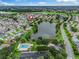 Aerial view of the community showcasing a pool, lake, clubhouse, and lush green spaces at 1889 Union Pl, The Villages, FL 32162