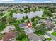 Aerial shot shows the home's location near a lake and surrounded by lush landscaping in a quiet neighborhood at 1889 Union Pl, The Villages, FL 32162