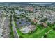 Aerial view of a residential neighborhood with a community pool, tennis courts, and a beautiful lake at 1889 Union Pl, The Villages, FL 32162