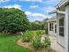 This backyard features manicured landscaping and a charming screened-in porch at 1889 Union Pl, The Villages, FL 32162