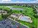 Aerial view of clubhouse with a pool, parking lot and golf course in the background at 1889 Union Pl, The Villages, FL 32162