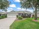 Charming single-story home boasts a well-manicured lawn, inviting curb appeal, and an attached two-car garage at 1889 Union Pl, The Villages, FL 32162