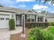 Charming single-story home boasts manicured landscaping, inviting curb appeal, and a walkway to the front door at 1889 Union Pl, The Villages, FL 32162