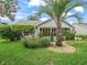 Exterior showcases a lawn and gardens that surround the charming screened-in porch at 1889 Union Pl, The Villages, FL 32162
