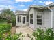 Exterior showcases a screened-in porch, adjacent patio, and lush, green landscaping at 1889 Union Pl, The Villages, FL 32162