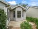 Home exterior showing a screened-in porch, adjacent patio, and manicured landscaping at 1889 Union Pl, The Villages, FL 32162