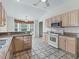 Eat-in kitchen with light wood cabinets, tile floor and granite countertops at 1889 Union Pl, The Villages, FL 32162