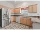 Kitchen featuring light wood cabinets, granite countertops, and stainless steel refrigerator at 1889 Union Pl, The Villages, FL 32162