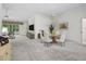 Bright living room with neutral carpet flooring, modern furnishings, a ceiling fan, and a view to the balcony at 1889 Union Pl, The Villages, FL 32162
