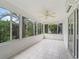 Bright sunroom with tiled floor, lots of windows with backyard views, and ceiling fan at 1889 Union Pl, The Villages, FL 32162