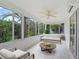 Bright sunroom with tiled floor, lots of windows with backyard views and neutral furniture at 1889 Union Pl, The Villages, FL 32162