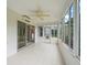 Tiled sunroom featuring many windows, leading to a backyard view, ceiling fan, and sliding glass door at 1889 Union Pl, The Villages, FL 32162