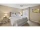 Bright bedroom with a ceiling fan, bedside table, and large window dressed with patterned curtains at 2055 Merideth Ter, The Villages, FL 34762