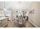 Dining area featuring a chandelier, table with seating for four, and a view of the kitchen at 2055 Merideth Ter, The Villages, FL 34762