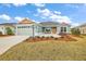 Charming single-story home featuring manicured landscaping and a welcoming front porch with seating at 2055 Merideth Ter, The Villages, FL 34762
