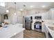 Bright kitchen featuring white cabinets, stainless steel appliances, and a spacious quartz countertop island at 2055 Merideth Ter, The Villages, FL 34762
